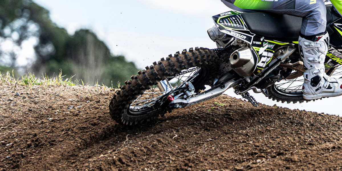 oto de enduro en terreno off-road con suspensión en acción sobre piedras y tierra suelta